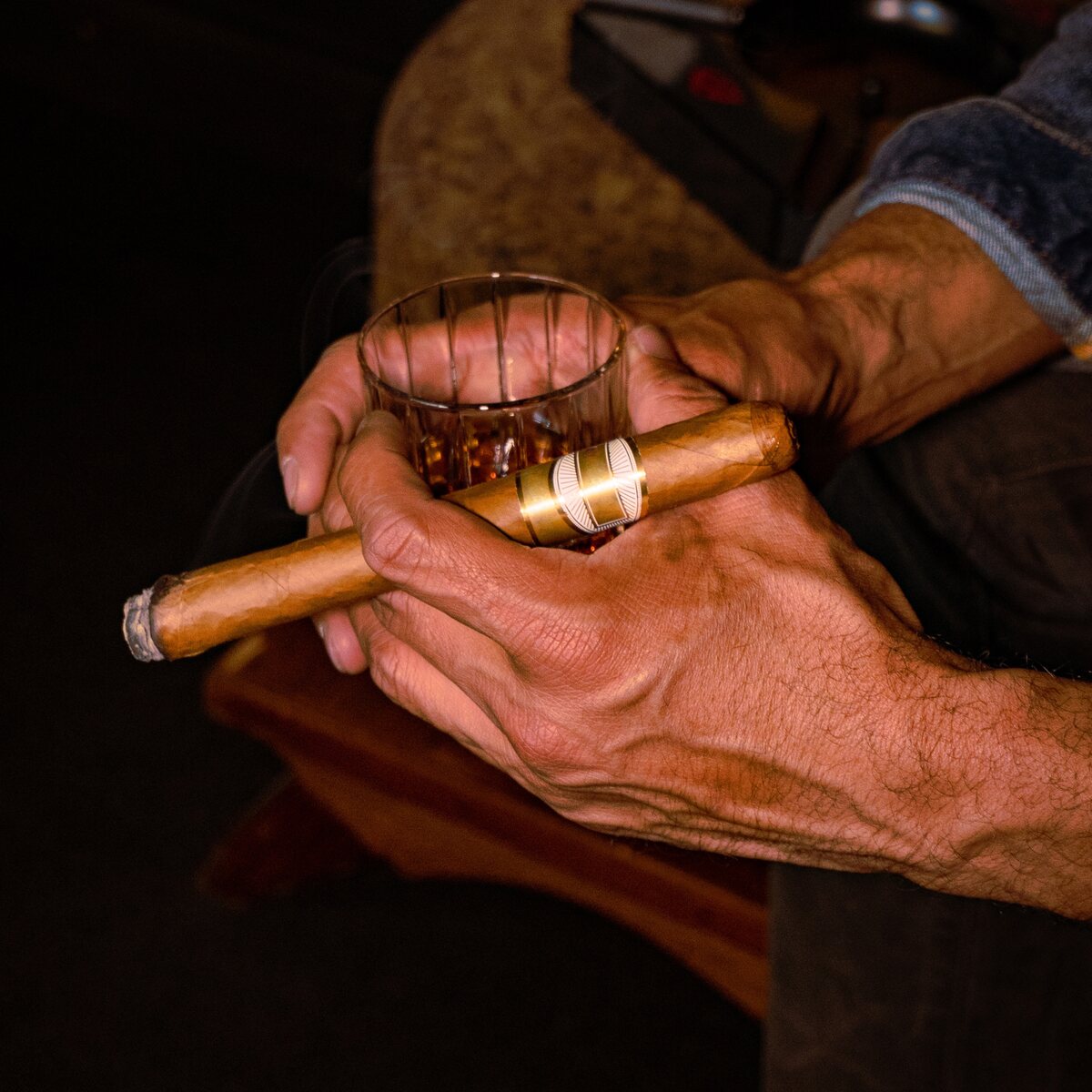 A guest enjoying a cigar and whisky at Huntsman
